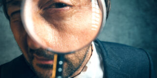 enlarged eye of tax inspector looking through magnifying glass